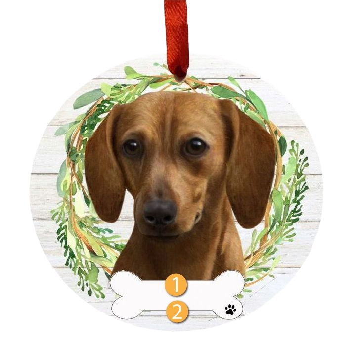 Round Christmas ornament featuring a red dachshund portrait framed by green wreath and red hanging ribbon