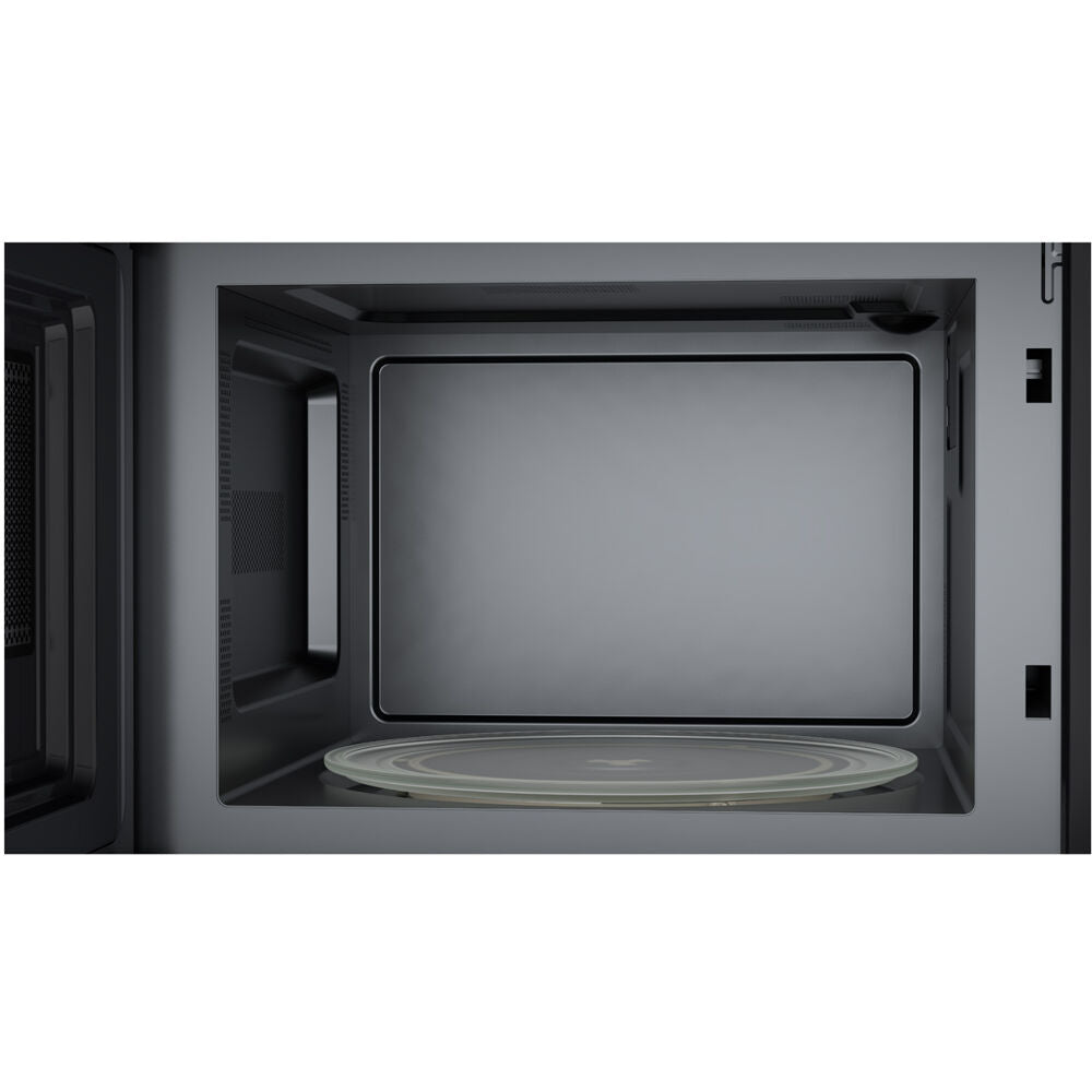 Interior view of sleek gray over-the-range microwave oven with glass turntable for kitchen appliances