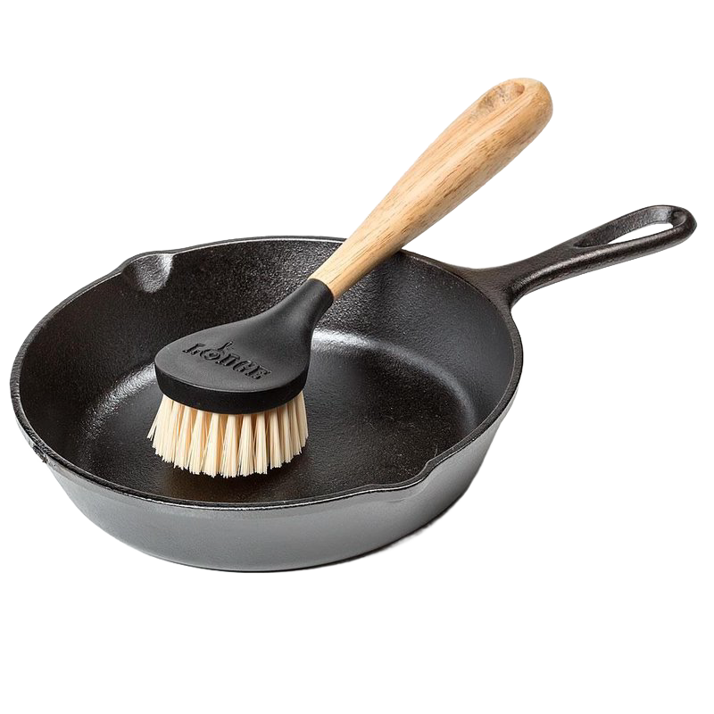 Stiff nylon scrub brush with wooden handle resting inside a black cast iron skillet for kitchenware cleaning tasks under $50 collection