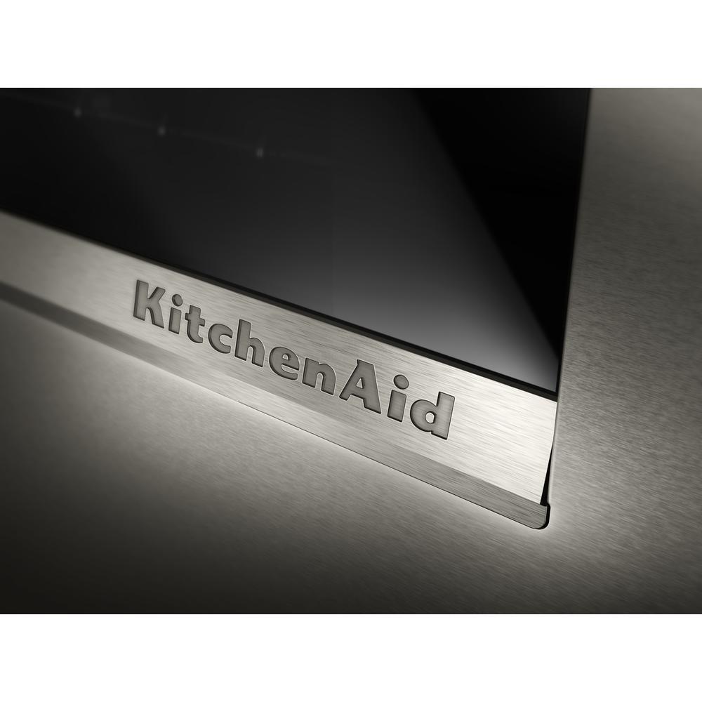 Close-up of brushed stainless steel KitchenAid logo on a black ore smart electric single wall oven panel