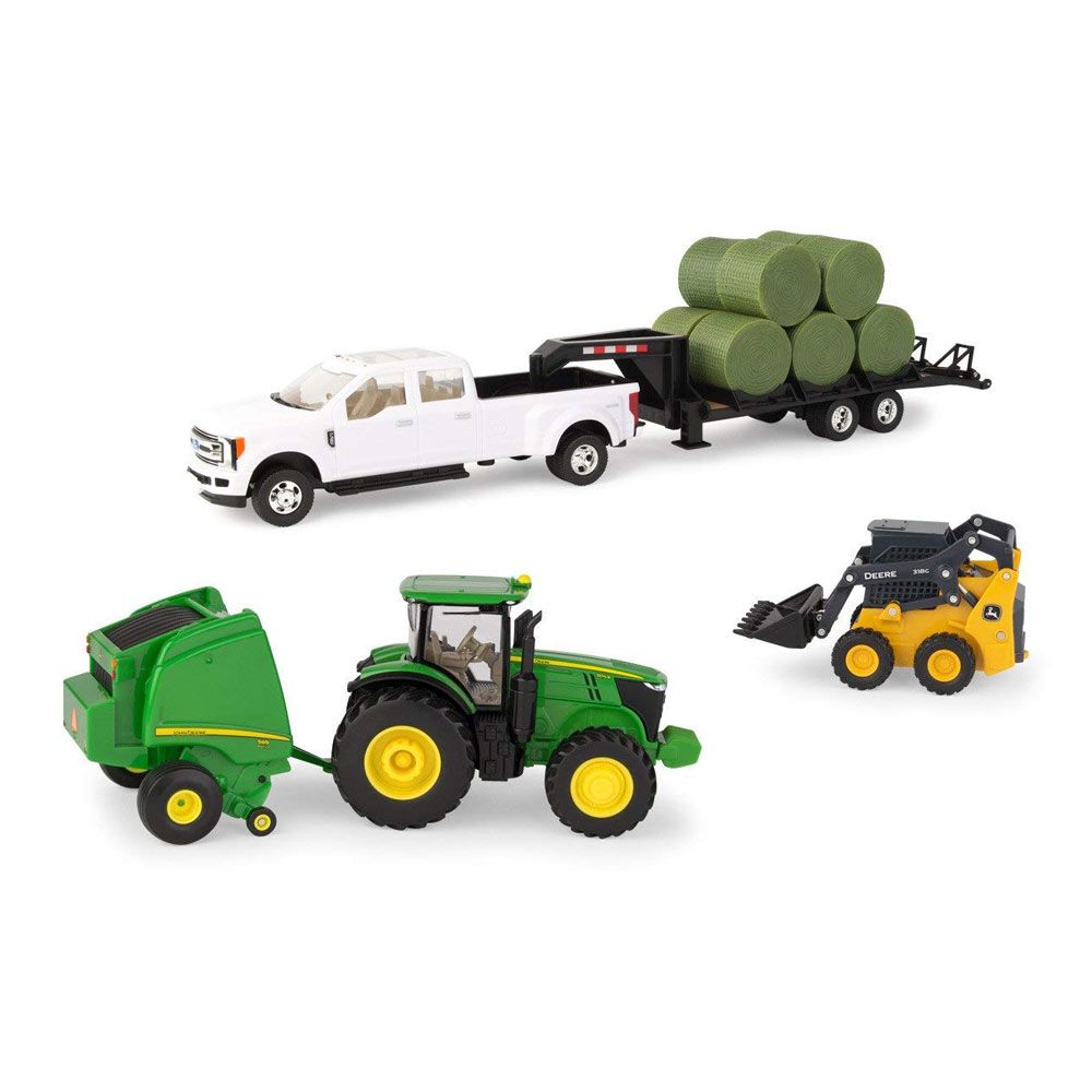 Toy farm set including green tractor with baler, white pickup with trailer carrying round hay bales, and yellow loader vehicle