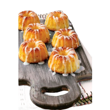 Six golden mini bundt cakes drizzled with white icing on a rustic wooden serving board