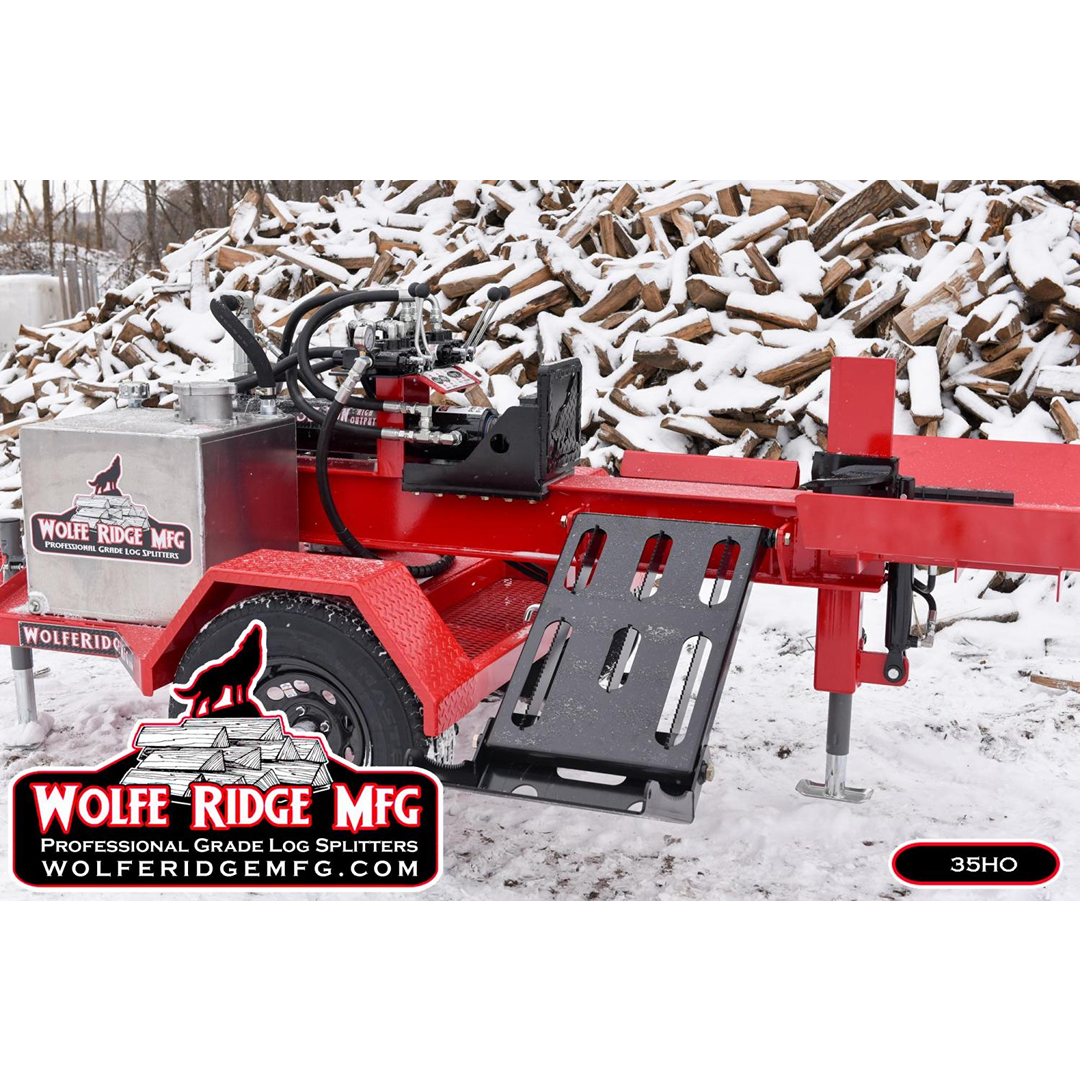 Red Wolfe Ridge log splitter parked outdoors on snow-covered ground with split firewood stacked in background