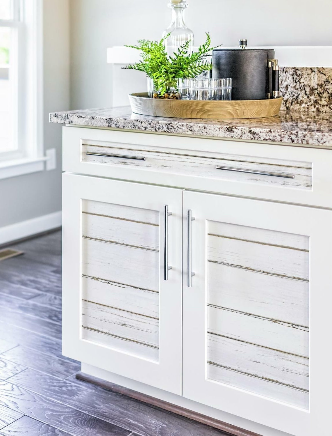 White lined shiplap wallpaper applied on cabinet doors with modern handles and granite countertop in home decor setting
