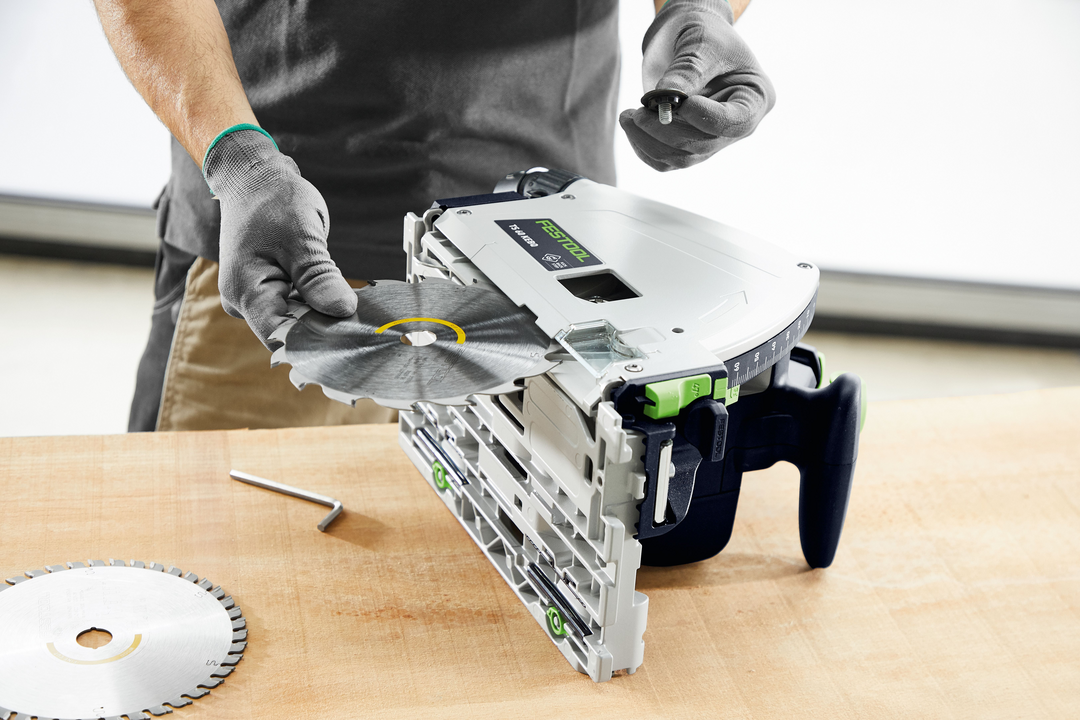 Person installing a circular saw blade into a Festool plunge cut track saw for power tools and home improvement use
