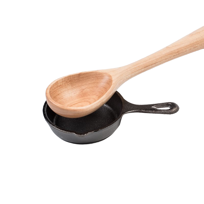 Small black cast iron skillet with wooden cooking spoon resting inside, from kitchenware and Lodge Cast Iron collection