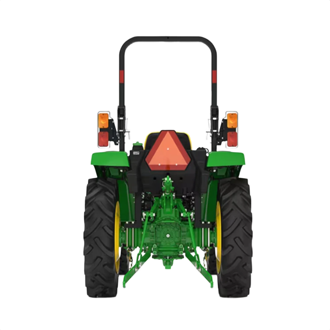 Rear view of green and yellow compact tractor equipped with rear hitch and safety triangle for agricultural use