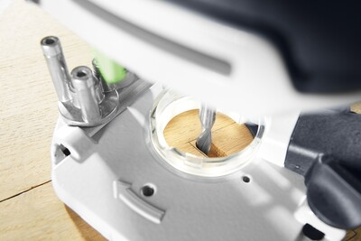 Close-up of a precision router bit engaging a light wood surface for detailed trimming in home improvement tasks