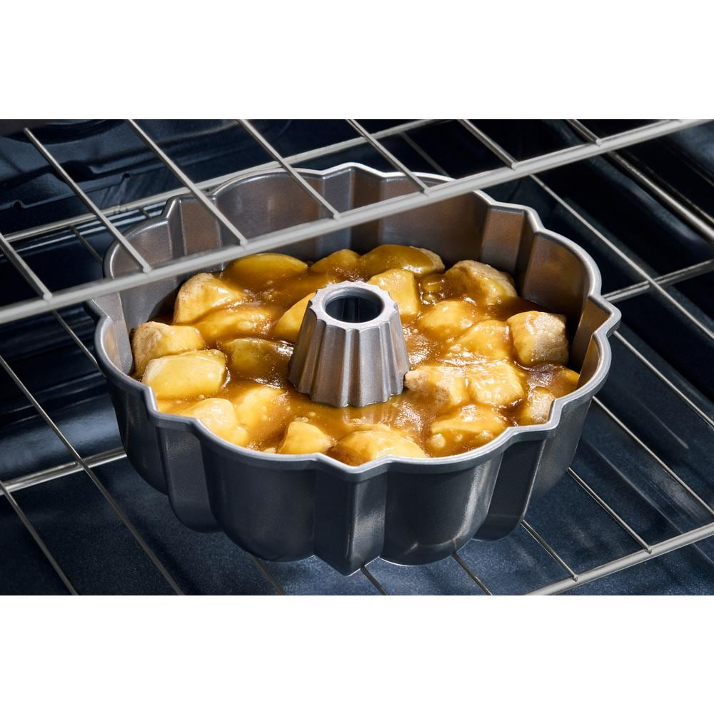Close-up of dessert baking in fluted cake pan inside stainless steel slide-in electric range oven cavity