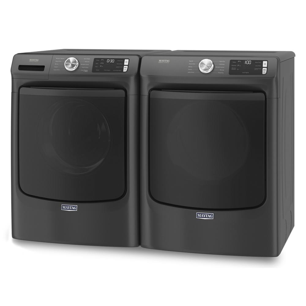 Pair of black front load washer and gas dryer with digital displays and control dials in modern laundry appliances setting