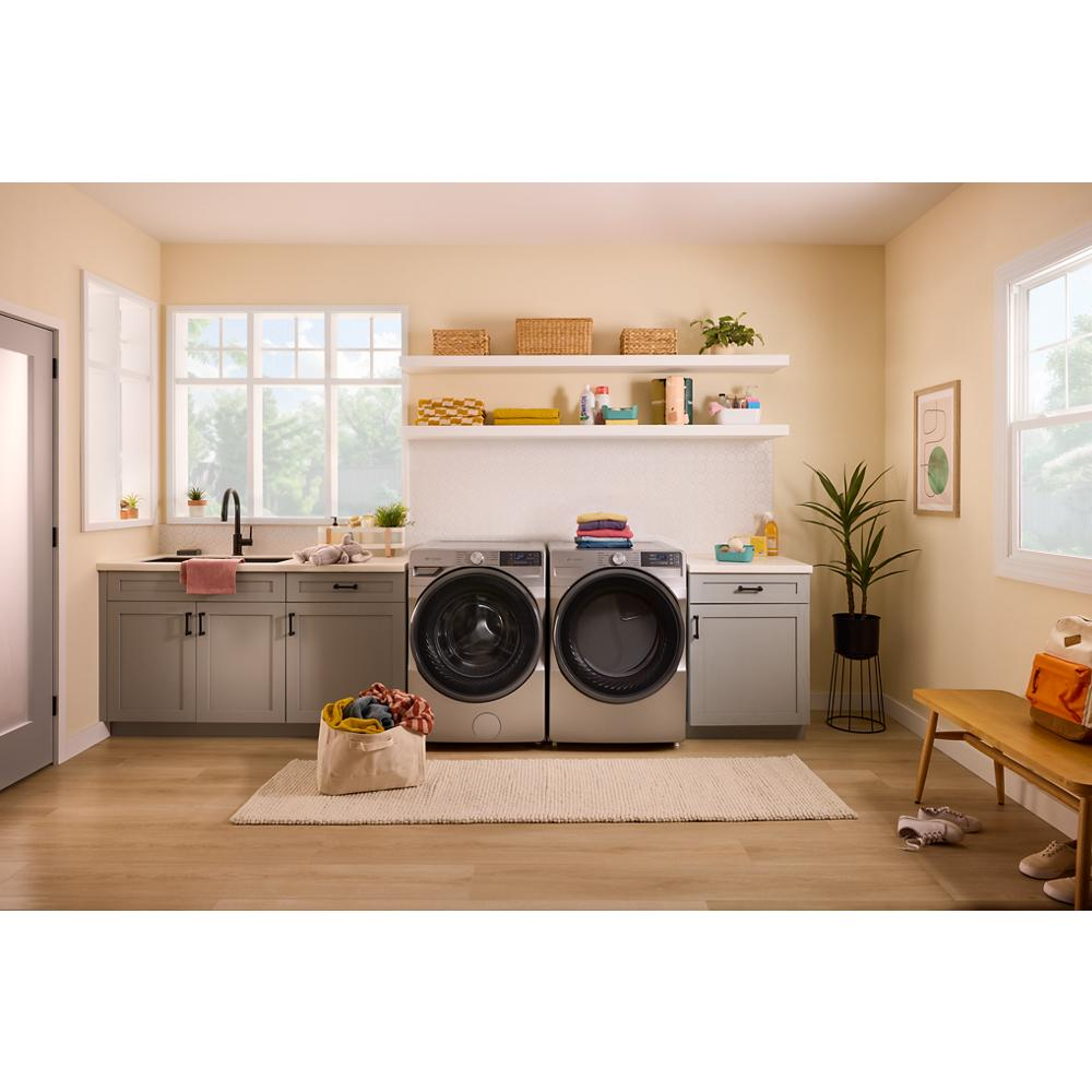 Bright laundry room with gray smart front load electric washer and dryer from the Dryers collection and cabinetry
