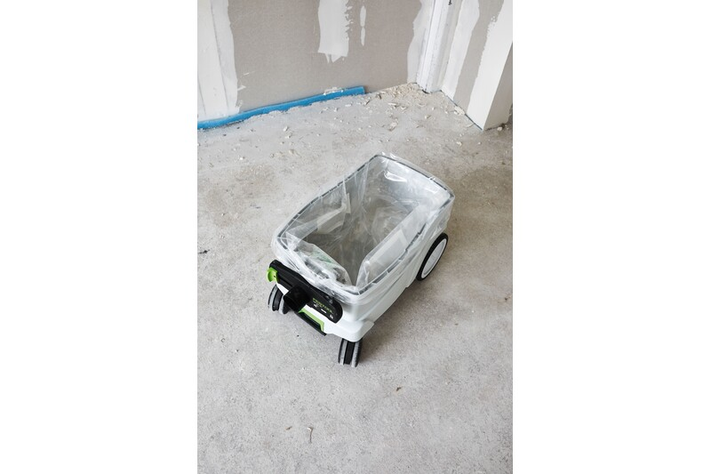 Clear disposable dust collection bag fitted inside a tool vacuum for home improvement use