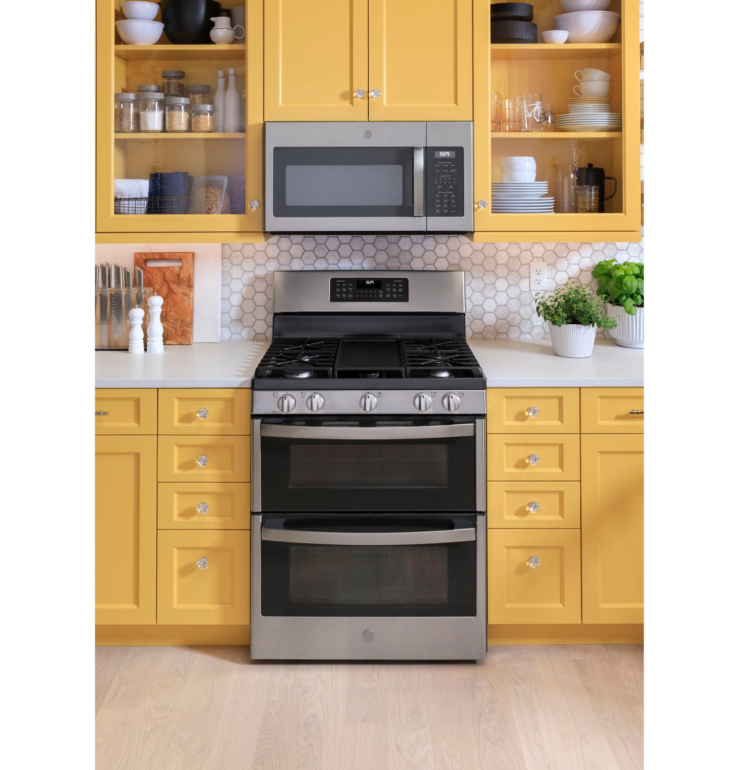 Stainless steel freestanding gas double oven with convection and four burner cooktop in modern kitchen setting