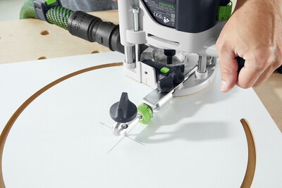 Hand operating Festool router with guide rail adapter for precise woodworking tool use in home improvement projects