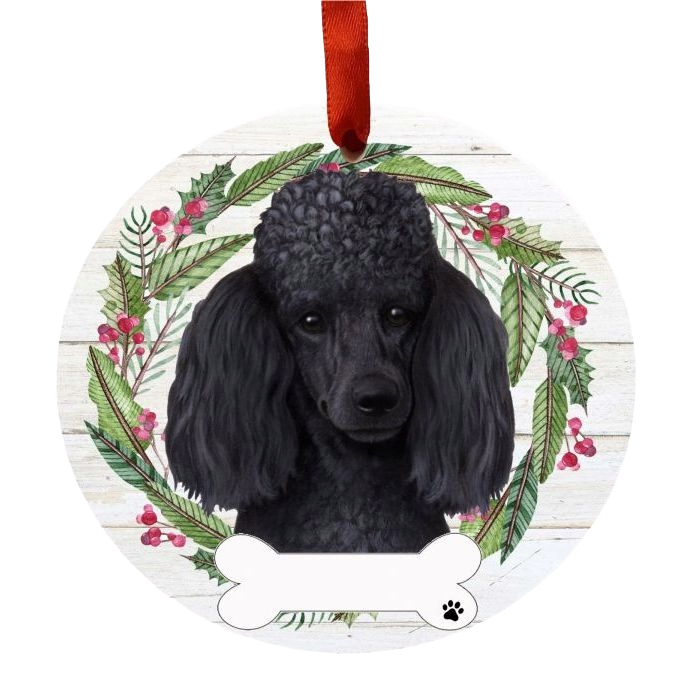 Round Christmas ornament with a black poodle face surrounded by greenery and red berry wreath, hanging by red ribbon