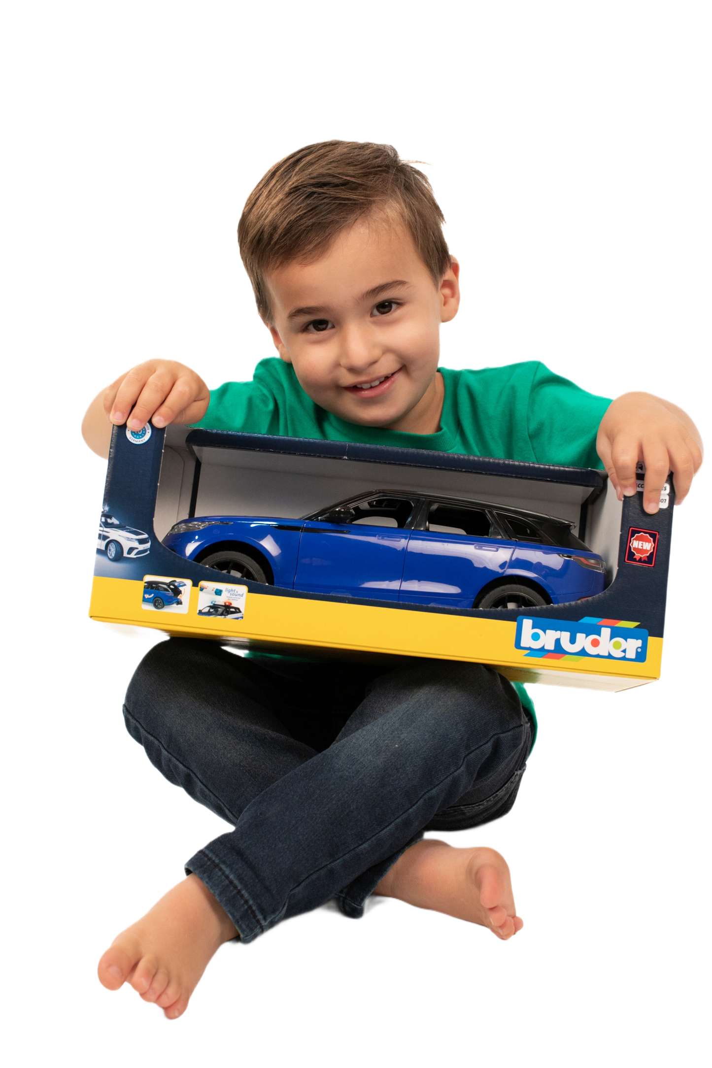 Young child holding boxed blue Bruder Range Rover Velar model for play and display purposes