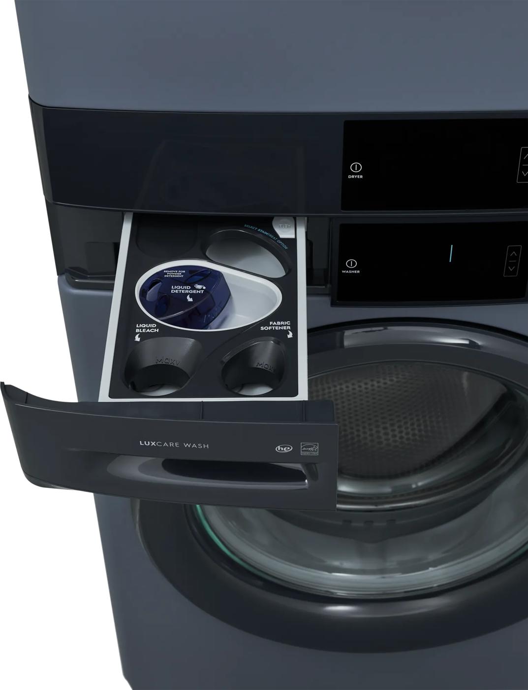 Close-up of a dark gray front load washer drawer open to show compartments for liquid detergent, bleach, and fabric softener, part of appliance laundry centers at Hartville Hardware.