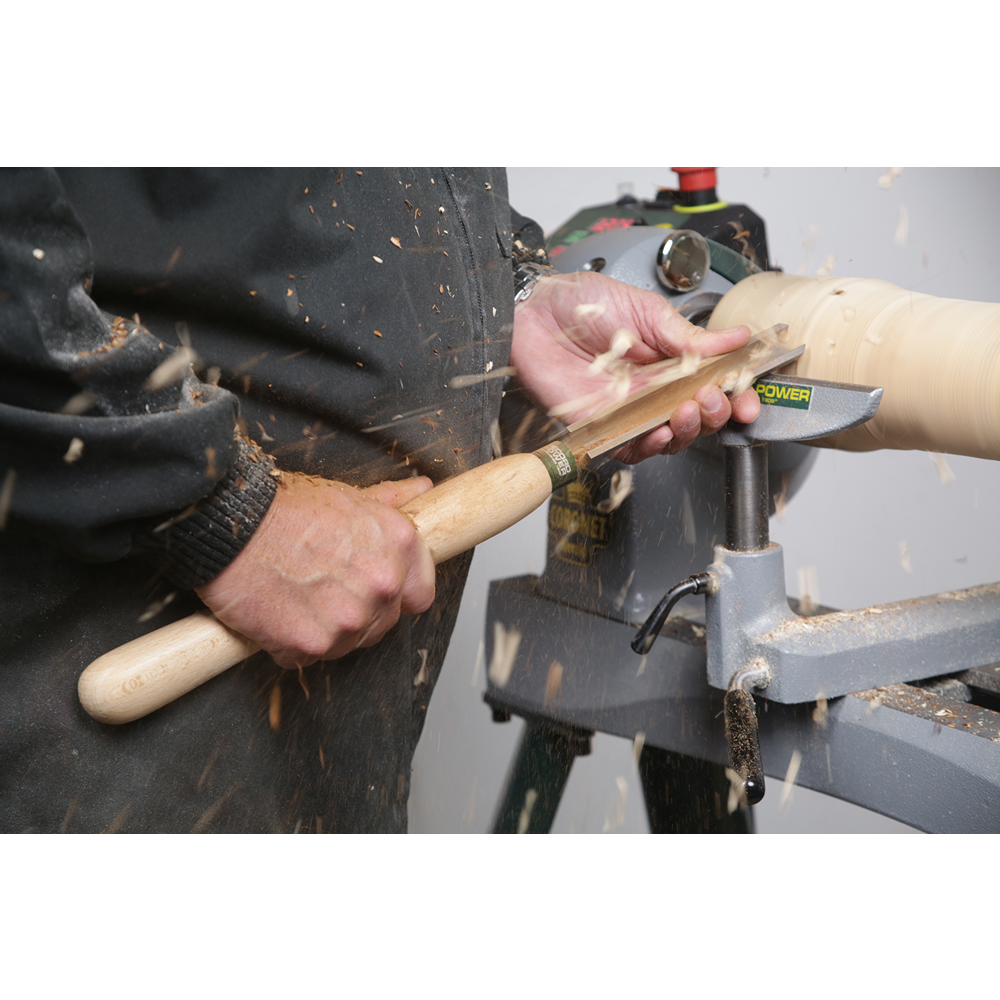 Person using a high-speed steel roughing gouge with a beech handle to shape wood on a lathe for home improvement tasks