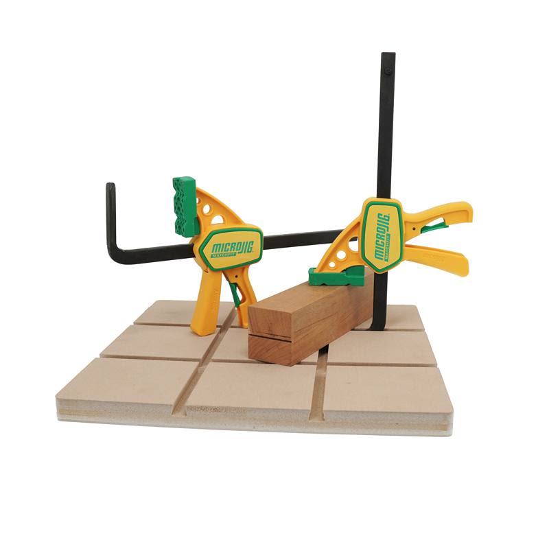 Two green and yellow Microjig clamps securing wood on a slotted board in clamping and tool accessories collections under $100