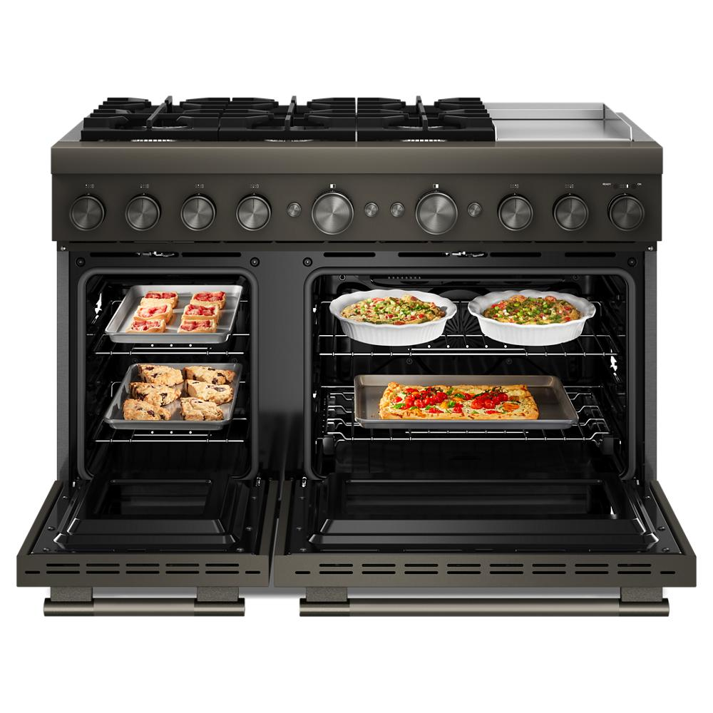 Front view of 48-inch commercial-style dual fuel range with six burners, electric griddle, and open double ovens cooking various dishes