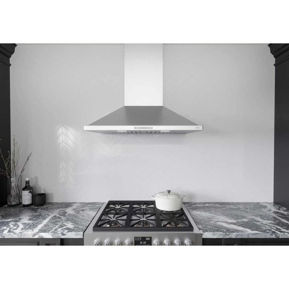Stainless steel wall mounted chimney hood with LED lighting above gas cooktop on marble countertop in modern kitchen