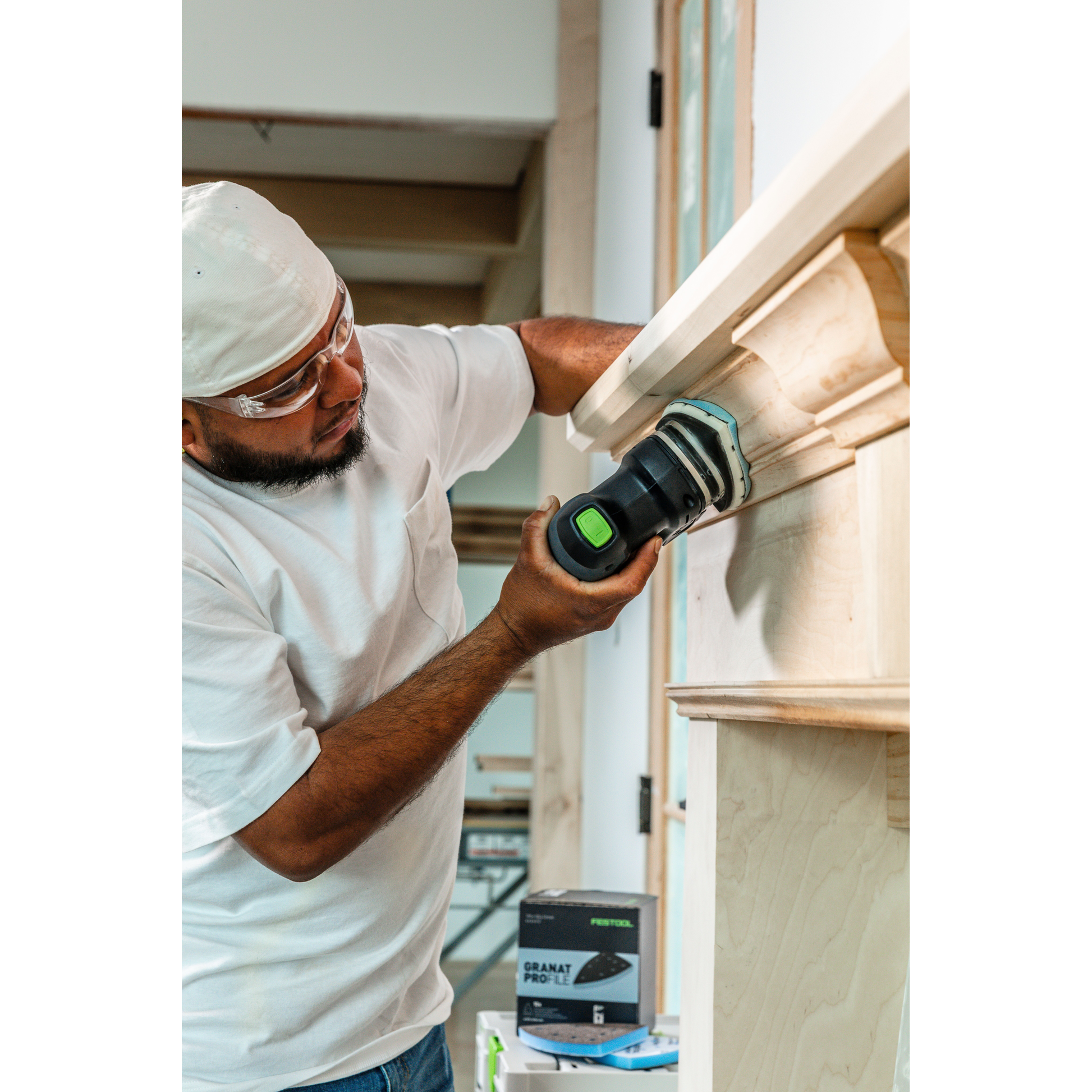 Man using power sander for detailed woodworking on fireplace mantel, part of Tool and Woodworking Accessories collections