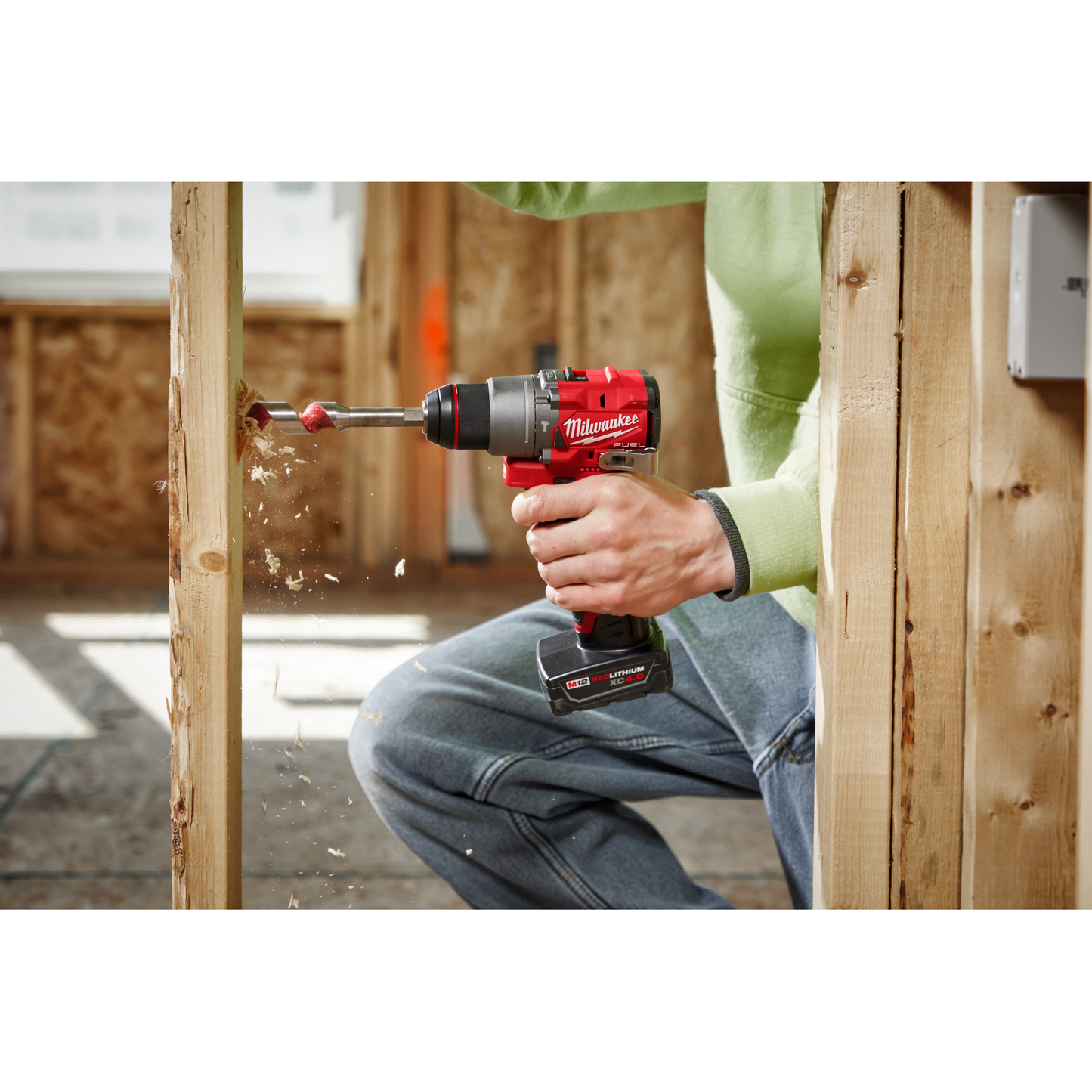 Person using Milwaukee M12 FUEL drill driver to bore hole in wooden framing for home improvement tools collection
