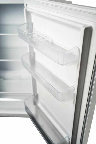 Open refrigerator door showing clear adjustable door shelving and interior compartments in kitchen appliance setting