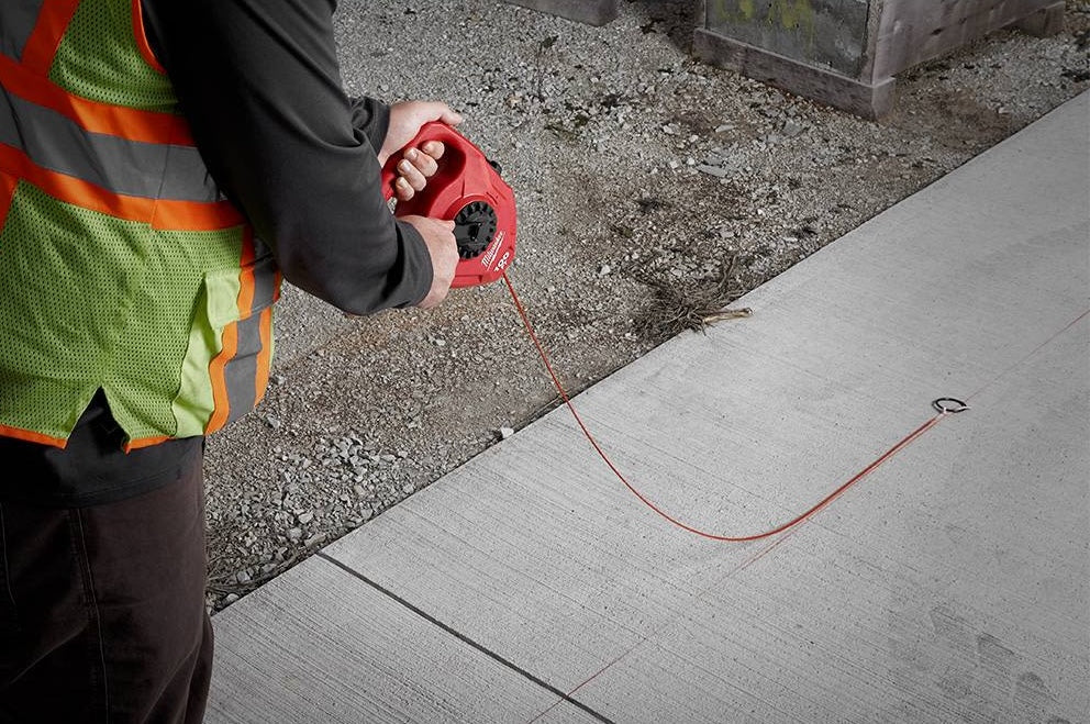 Worker using red chalk reel with large capacity and planetary gear for precise measuring in woodworking and home improvement tools collections