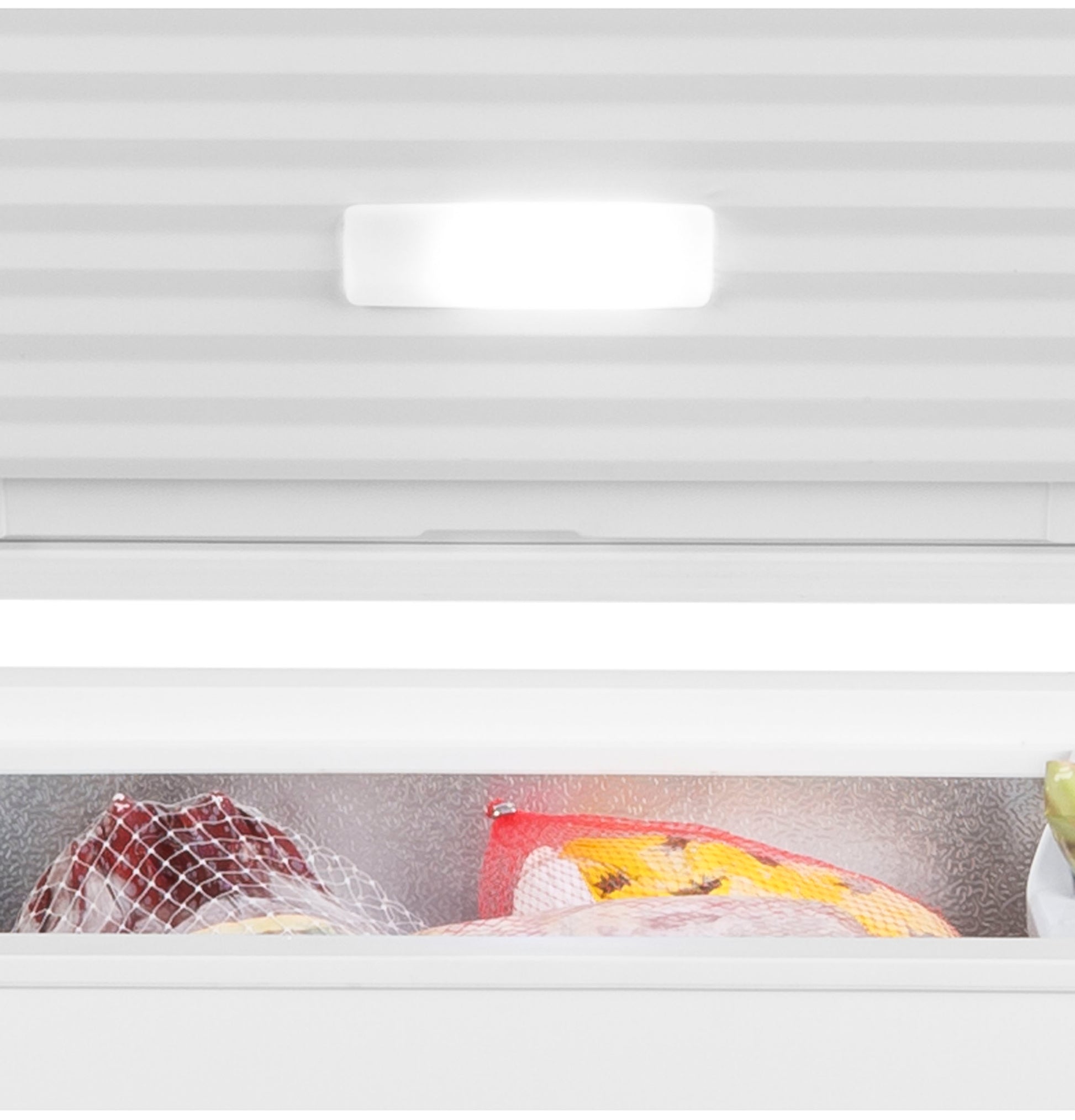 Interior view of chest freezer showing bright interior light and frozen food items inside the storage compartment