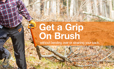 Person gripping orange LogOX Hauler tool to move brush in a forest while protecting their back in home improvement tasks