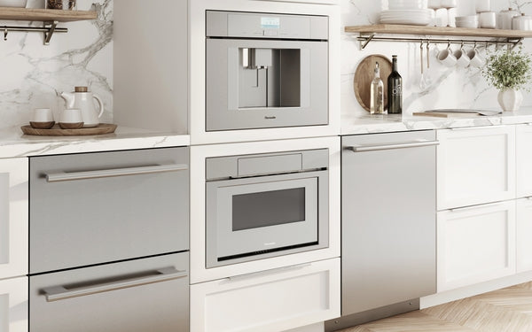 Built-in stainless steel microwaves and appliances integrated into white kitchen cabinetry with marble backsplash