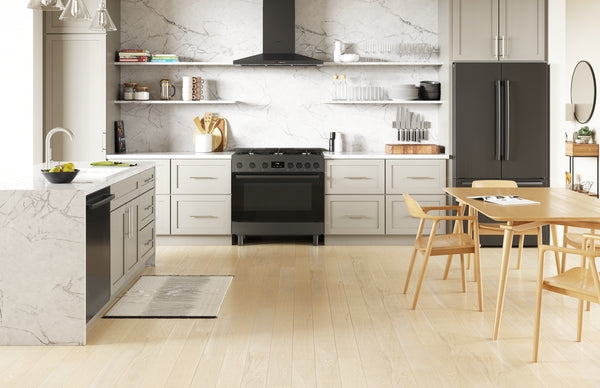 Modern kitchen with black stainless steel gas range, matching refrigerator, and white cabinetry in bright space