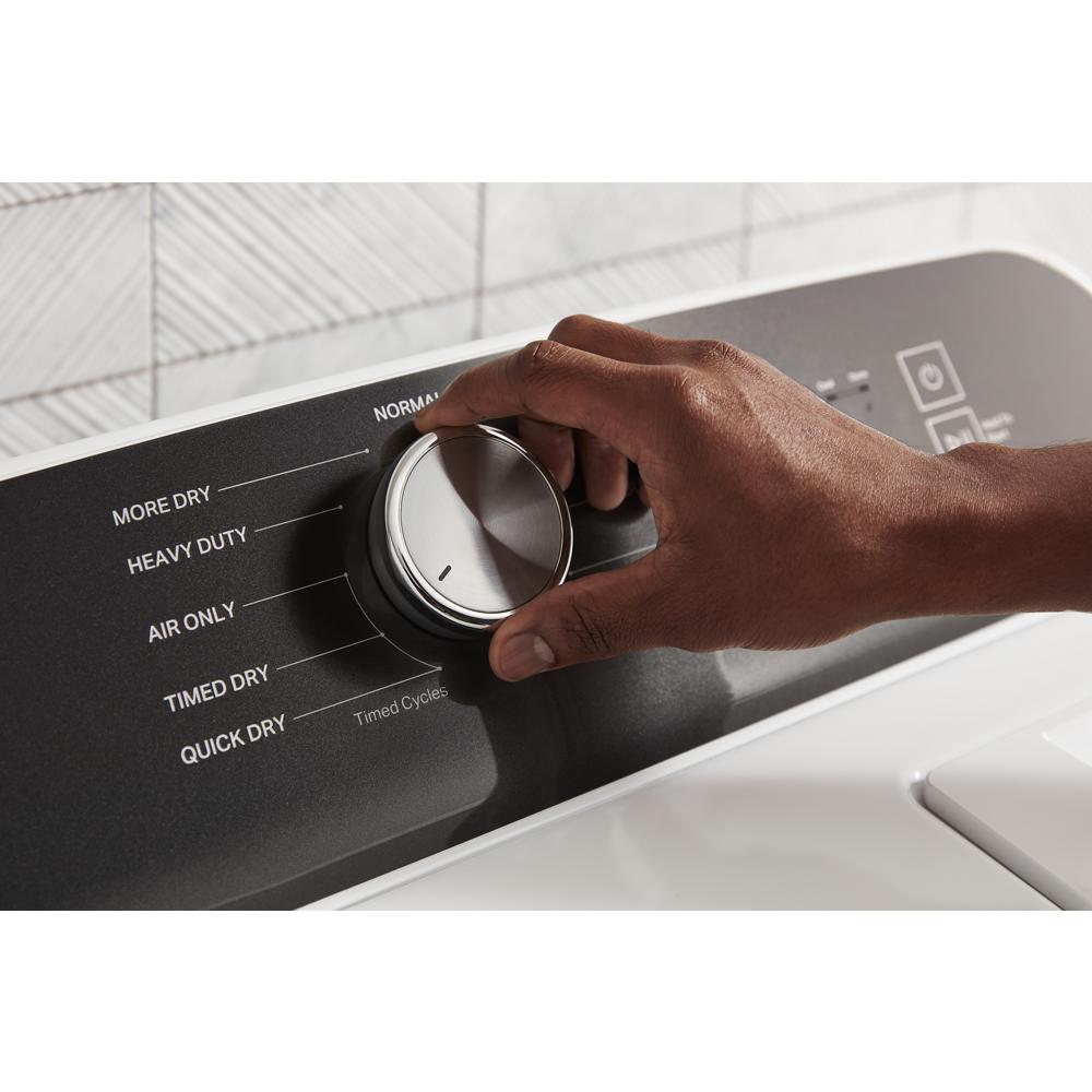 Hand adjusting cycle selection dial on a black control panel of a home appliance in Dryers collection