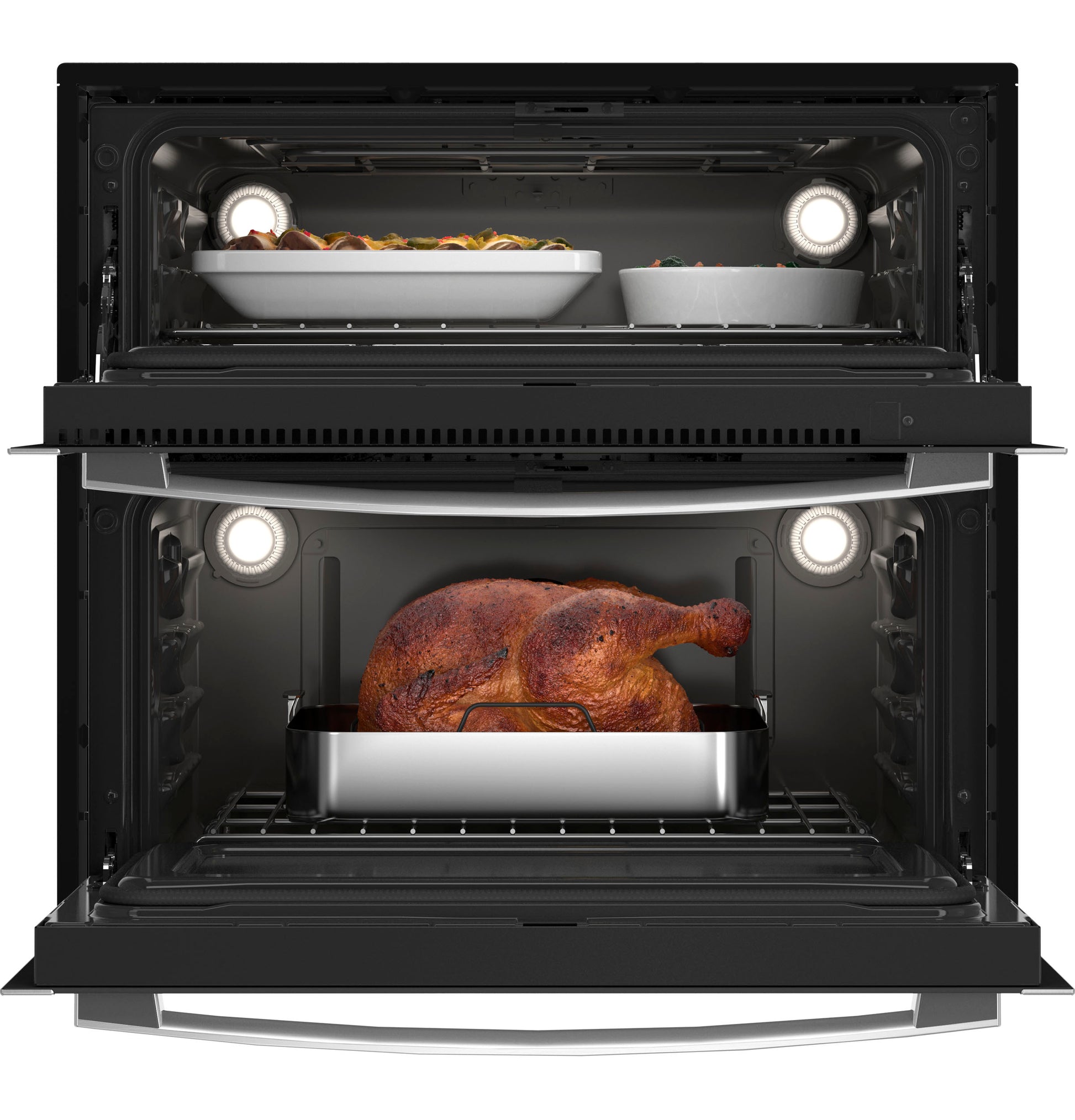 Open black double flex convection wall oven with interior lights showing food dishes inside in kitchen appliances collection