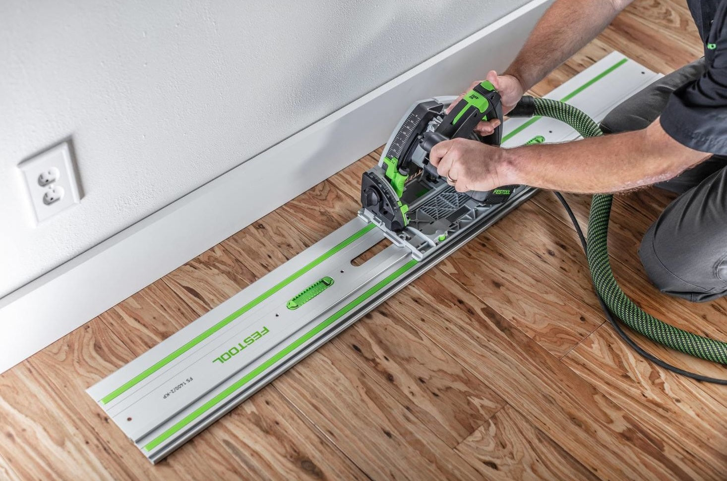 Professional using a Festool guide rail with circular saw for precise straight cuts on hardwood flooring in woodworking projects