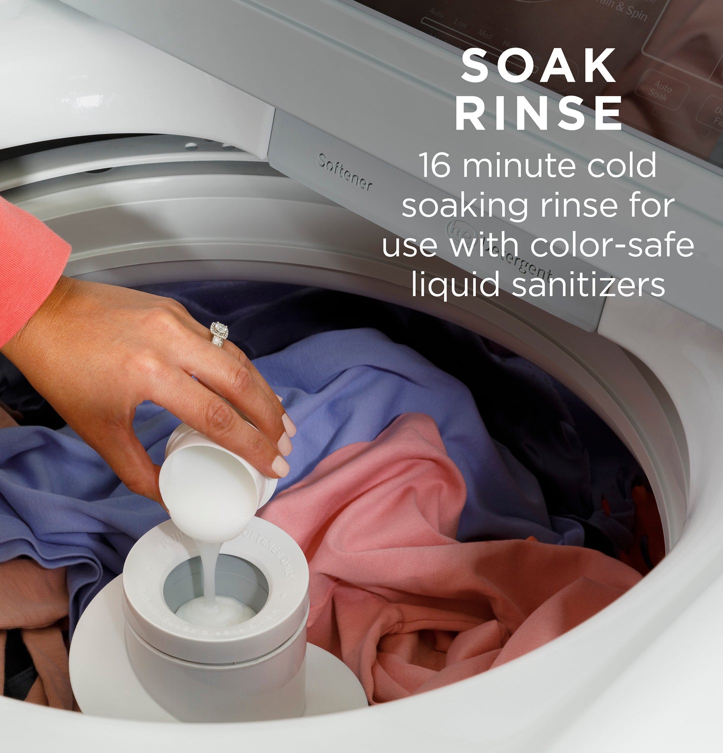 Person pouring detergent into a white top load washer filled with colorful clothes in a home appliances setting
