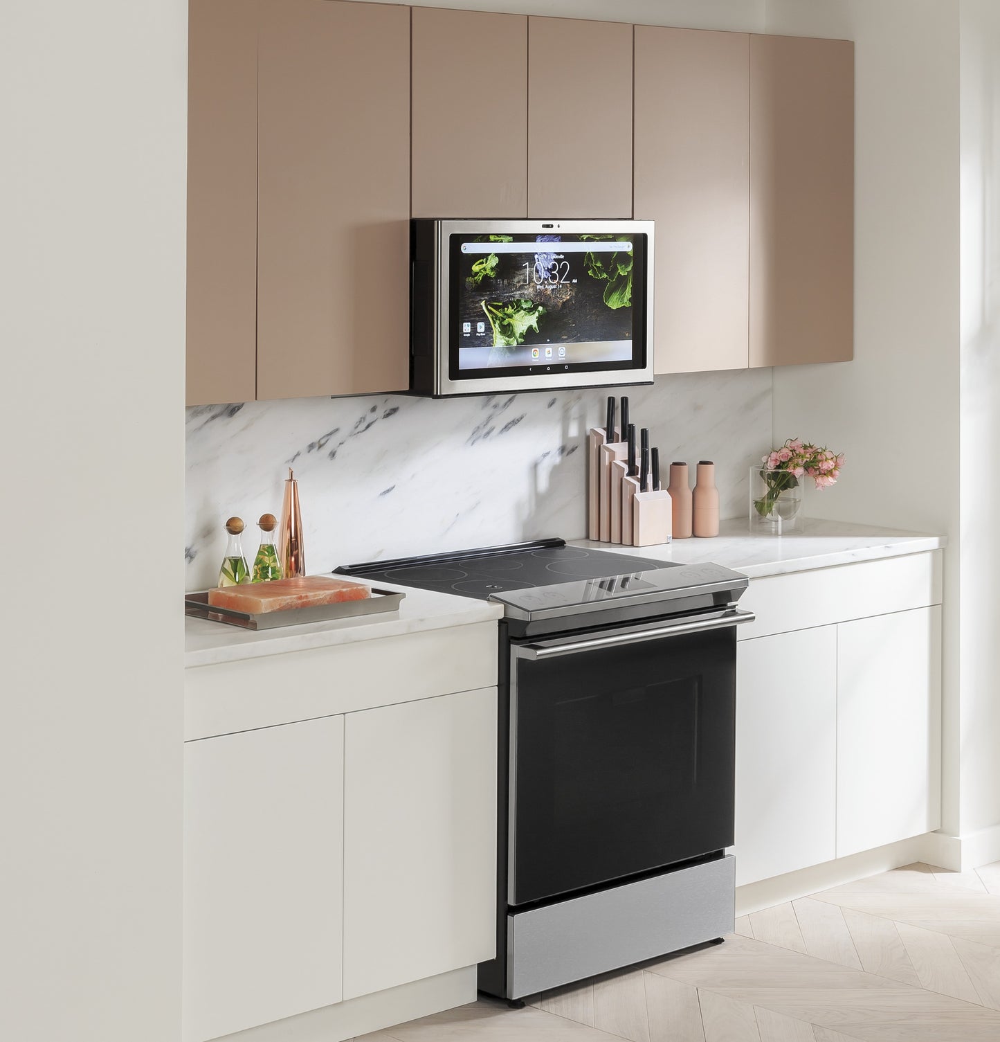 Black induction and convection slide-in range with digital screen mounted above in modern kitchen with marble backsplash