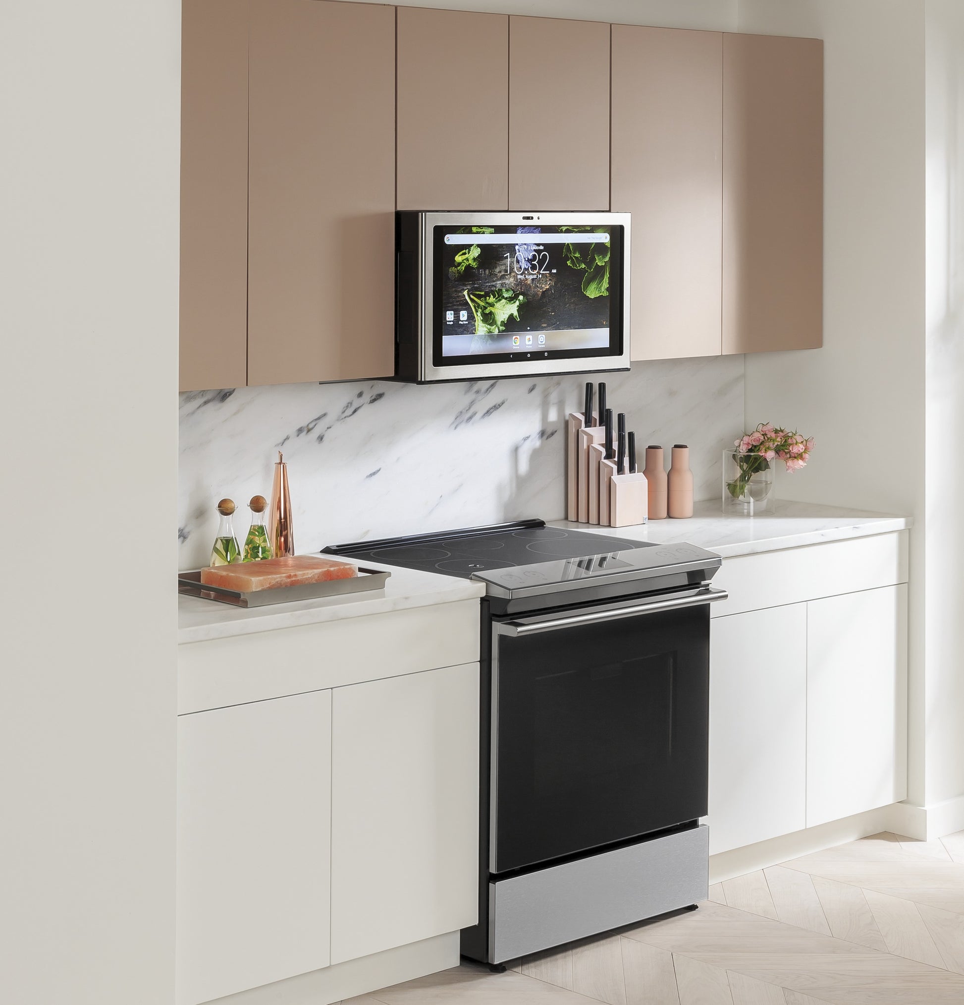Black induction and convection slide-in range with digital screen mounted above in modern kitchen with marble backsplash