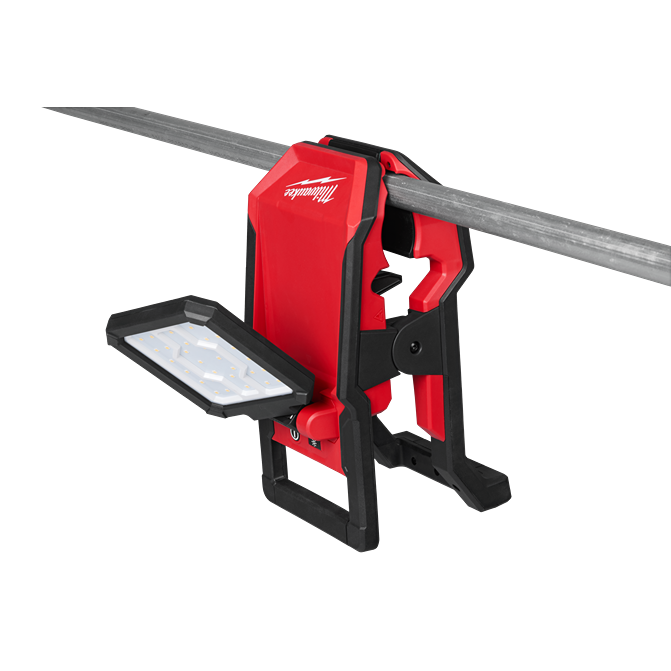 Red and black Milwaukee utility flood light clamped to metal pipe with adjustable LED panel for work light applications