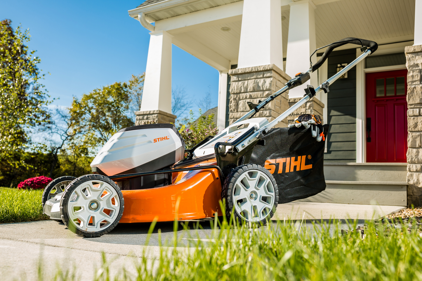 Orange and white STIHL battery-powered lawn mower with steel deck and grass catcher for outdoor power equipment collections