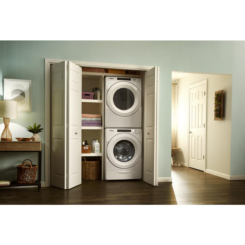 Stacked white front load washer and electric dryer with shelves in a home laundry closet for appliances and home improvement