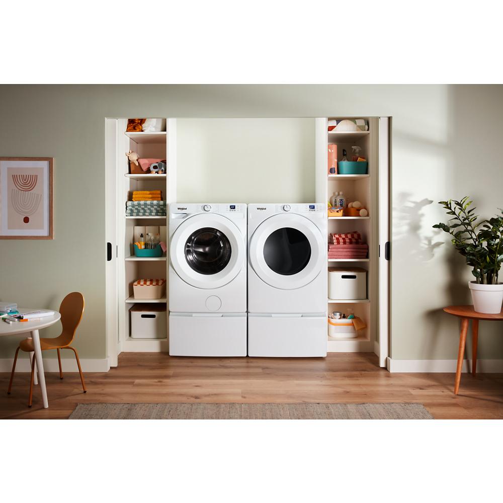 White front load washer and dryer set with large round doors, digital controls, and built-in storage shelves in laundry area