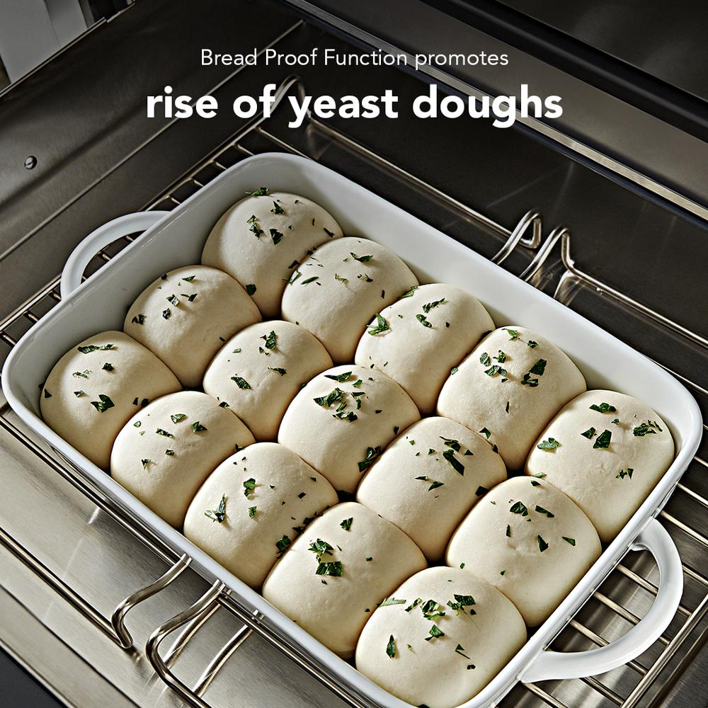 Yeast dough rising in white baking dish inside stainless steel warming drawer from KitchenAid appliances collection
