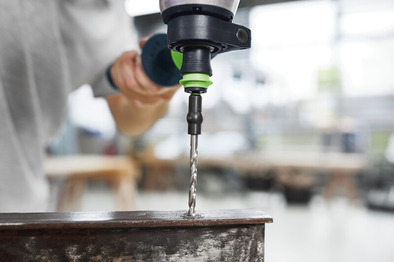 Handheld drill with metal spiral bit creating a precise hole in rusted steel for tools and home improvement