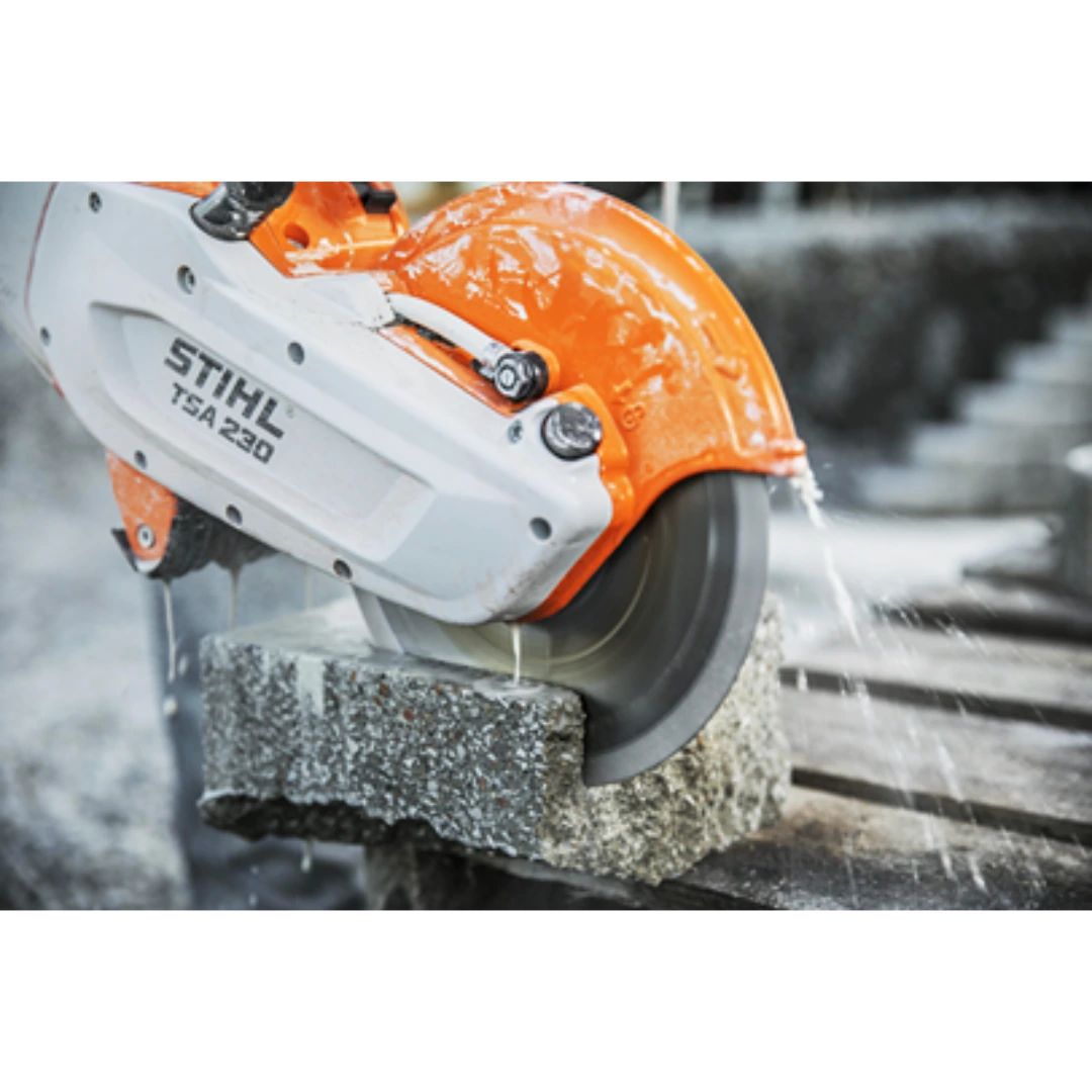 Orange and white portable cut-off saw slicing concrete block with water cooling for tools and home improvement tasks