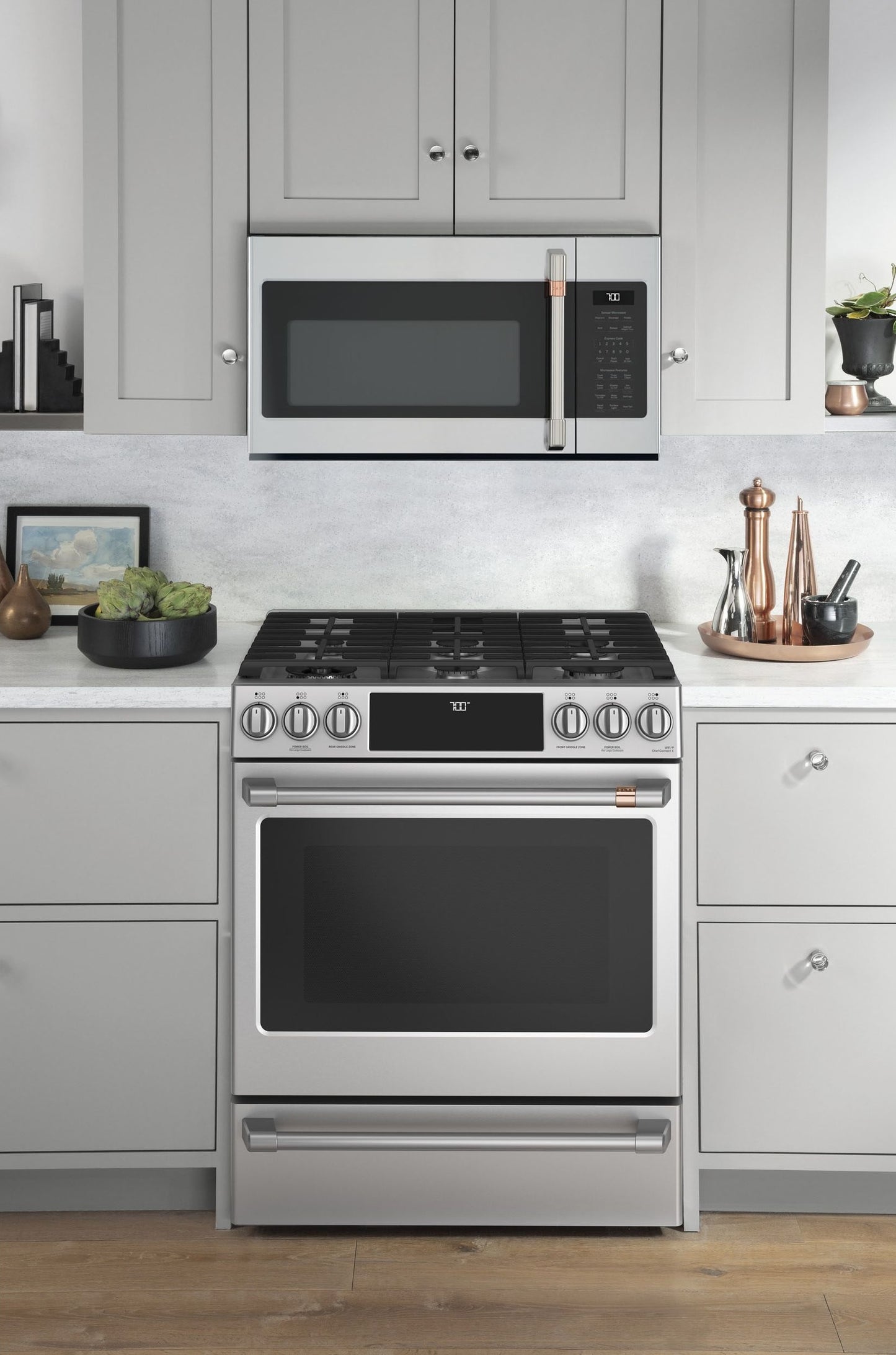 Modern stainless steel over-the-range microwave above matching gas range in a contemporary kitchen setting
