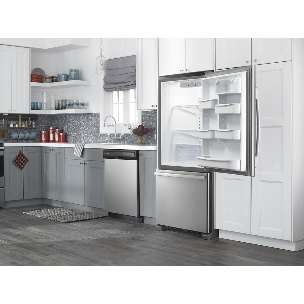 Modern kitchen featuring stainless steel refrigerator with open door and bottom freezer drawer, gray cabinets, and hardwood floor