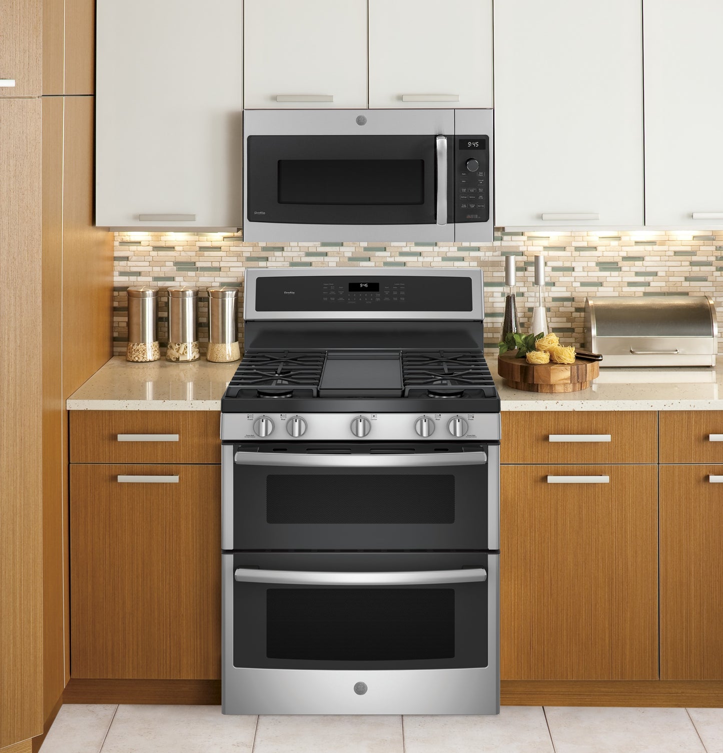 Stainless steel GE Profile over-the-range oven with Advantium technology and gas cooktop in modern kitchen setting