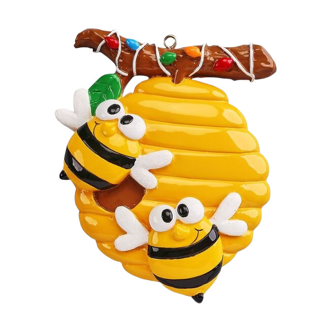 Yellow beehive ornament with two cheerful bees hanging from a Christmas lights-wrapped branch from holiday decorations under $50
